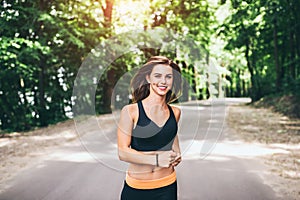 Young fitness girl running and listening music in the park