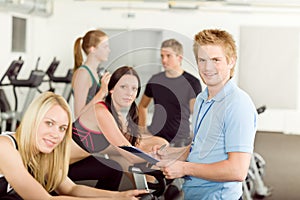 Young fitness instructor gym people spinning