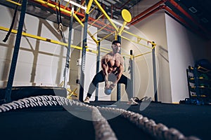 Fitness man doing a weight training by lifting heavy kettle bell