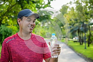 Young fitness man runner  drinking bottle of water