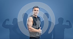Young fitness man standing sideways and showing thumb up.