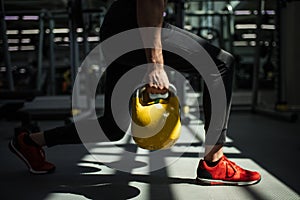 Young fitness man is training by kettlebell.