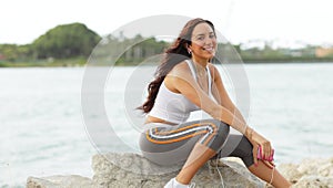 Young fitness model sitting on the rocks