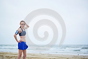 Young fitness running woman jogging on beach