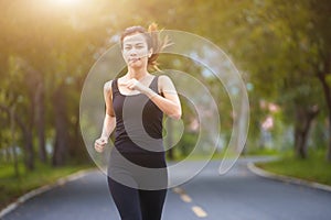 Young fitness sport woman running on the road in the morning, Sun light flare