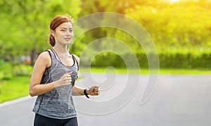 Young fitness sport woman running on the road in the morning, Young fitness sportswoman runner running on tropical park trail. Peo