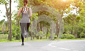 Young fitness sport woman running on the road in the morning, Young fitness sportswoman runner running on tropical park trail. Peo