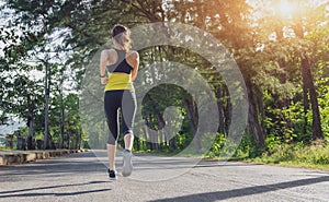 Young fitness sport woman running on the road in the morning, Young fitness sportswoman runner running on tropical park trail. Peo