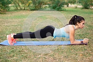 Young fitness sporty girl woman doing plank exercise during training workout