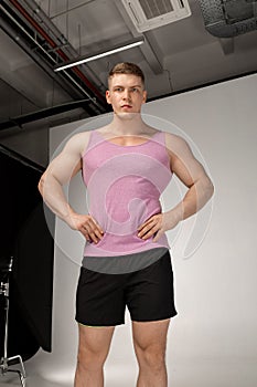 Young fitness sporty man in pink t-shirt and black shorts