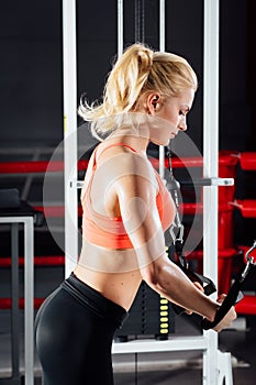 Young fitness woman demonstrate crossover exercises. The pectoral muscles, hard training with exercise-machine Cable