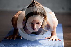 Young fitness woman doing chaturanga dandasana pose