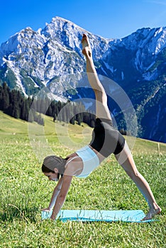 Young fitness woman doing morning yoga or pilates relax exercise mountains background