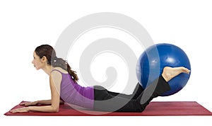 Young fitness woman doing pilates exercises with a pilates ball