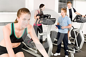 Young fitness woman doing spinning with instructor