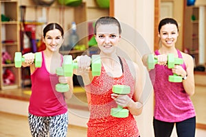 Young fitness woman with dumbbell in gym