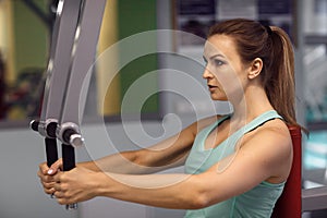 Young fitness woman execute exercise with exercise-machine in th