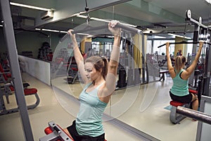 Young fitness woman execute exercise with exercise-machine in th