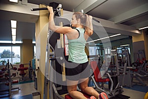 Young fitness woman execute exercise with exercise-machine in th