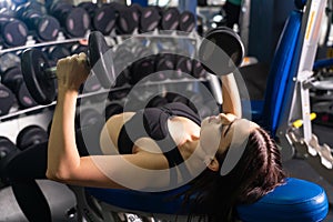 Young fitness woman execute exercise with machine in gym