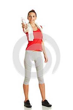 Young fitness woman giving bottle of water