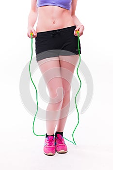 Young fitness woman with healthy sporty figure with skipping rope