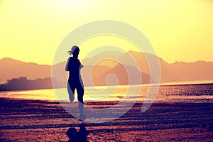 Young fitness woman jogging at beach