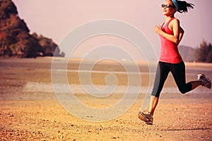 Young fitness woman jogging at beach