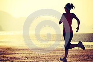 Young fitness woman jogging at beach