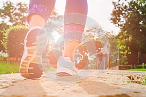 Young fitness woman legs walking in the morning for warm up body for jogging and exercise at outdoor public park