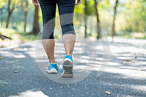 young fitness woman legs walking in the park outdoor, female runner running on the road outside, asian athlete jogging and exercis