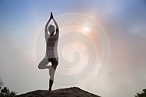 Fitness woman meditating on sunrise mountain peak