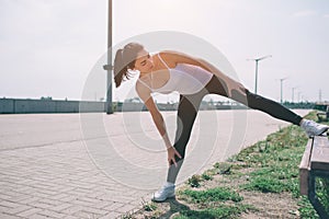 Young fitness woman runner stretching legs before run