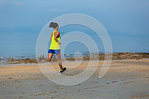 Young fitness woman running at morning beach