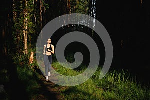 Young fitness woman running in the morning in a pine forest