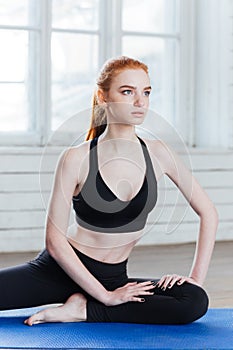 Young fitness woman sitting in yoga position