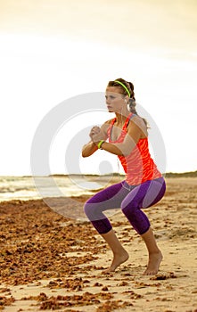 Young fitness woman in sport clothes on seacoast workout