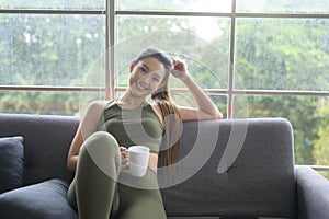 Young fitness woman in sportswear having a cup of coffee after exercising at home, Healthy and Lifestyles