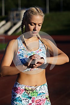 Young fitness woman is standing at stadium