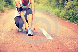 Young fitness woman tying shoelaces