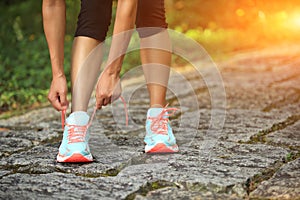 Young fitness woman tying shoelaces