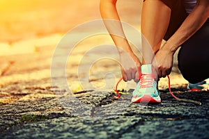 Young fitness woman tying shoelaces