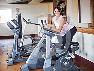 Young fitness woman working out in the gym. Woman working out on exercise bike