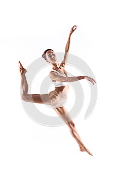 Young flexible woman gracefully jumping isolated on white background