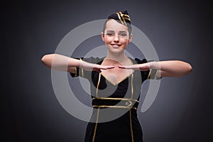 The young flight attendant on gray background