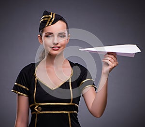 Young flight attendant on gray background