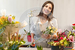 Young florist woman in a flower shop