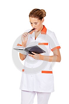 Young focus female doctor or nurse makes notes