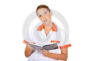 Young focus female doctor or nurse makes notes