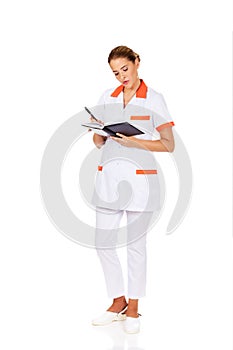 Young focus female doctor or nurse makes notes